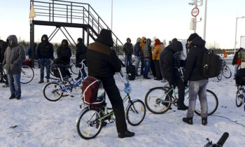 Refugees and migrants gather near a check point on the Russian-Norwegian border outside Nickel (Nikel) settlement in Murmansk region, Russia, October 30, 2015. The flow of Middle Eastern migrants trying to reach Europe via the Russian Arctic slowed dramatically on October 29, partly due to a shortage of bicycles to cross the border, a source who deals with them told Reuters. According to officials, many Syrians obtain business or study visas to enter Russia and then travel through Moscow and Murmansk to Nickel, a town of some 12,000 population named after the metal mined there. REUTERS/Fyodor Porokhin - RTX1TYCL