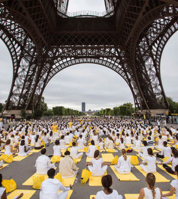 Participants perform yoga under the Eiffel Tower in Paris, France