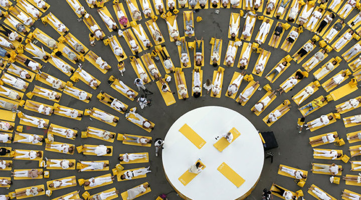 Participants perform yoga under the Eiffel tower in Paris