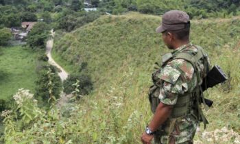 A FARC (Revolutionary Armed Forces of Colombia) rebel monitors the delivery of released hostages from a cocoa plantation in Monte Alegre province, in the department of Valle del Cauca February 15, 2013. REUTERS/Jaime Saldarriaga